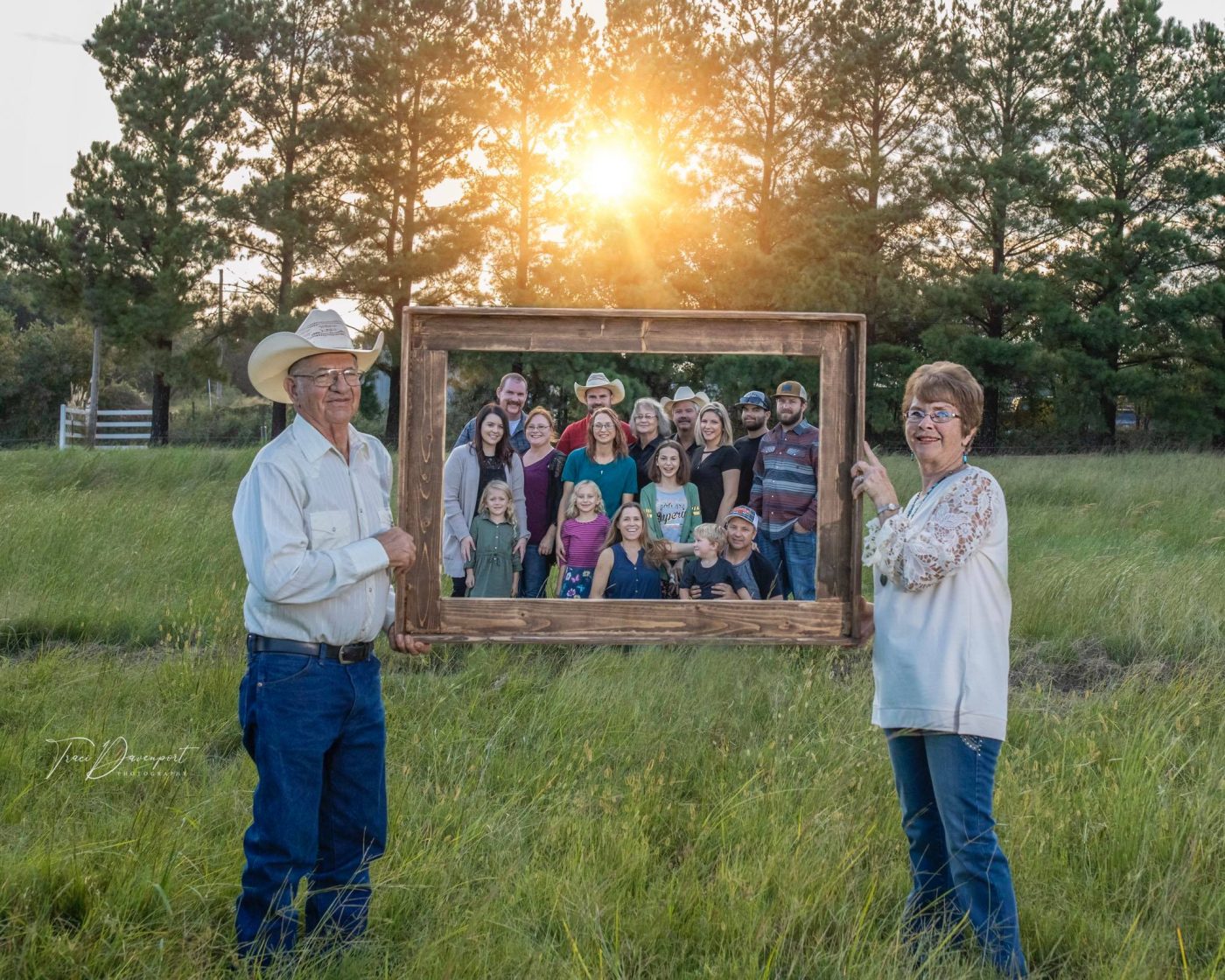Eugene and Susie Davenport holding a frame around three generations of the Davenport family